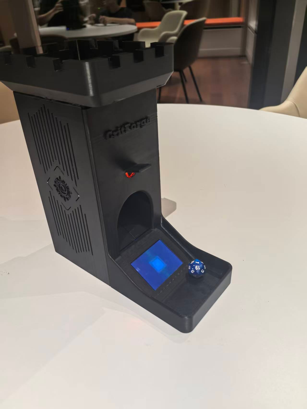 XbotPark smart dice tower prototype with blue screen and d20 die